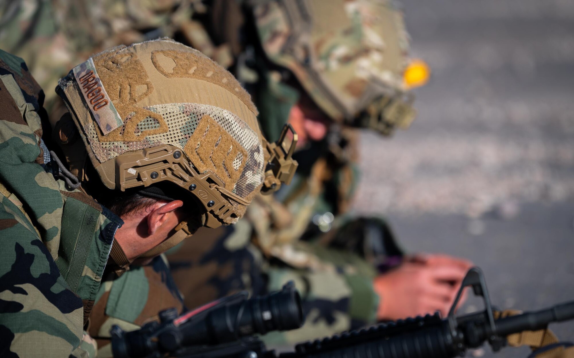 A close-up of a 944th Fighter Wing U.S. Air Force Reserve Citizen Airman’s helmet while he dawns Mission Oriented Protective Posture (MOPP) gear during Exercise Desert Hammer 25-1 at Auxiliary Field 6 near Gila Bend, Ariz., Nov. 15, 2024. Through joint and multinational collaboration, Desert Hammer tests the ability of over 700 participants and 131 aircraft to operate, defend, and sustain airbases under austere conditions. (U.S. Air Force photo by Senior Airman Jacob Dastas)