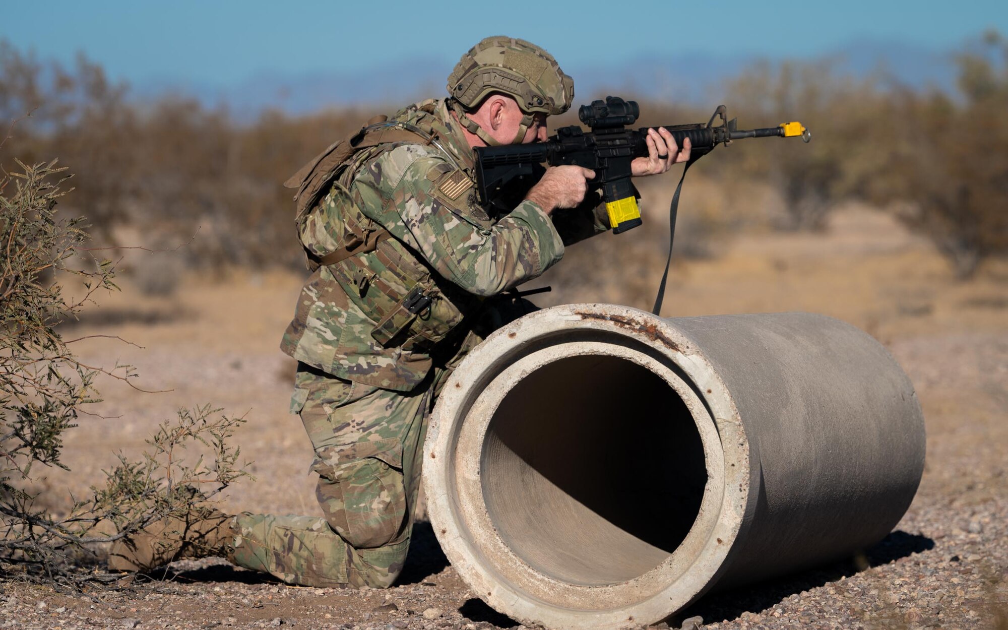 A 944th Fighter Wing U.S. Air Force Reserve Citizen Airman takes cover behind a concrete pipe and aims during a defensive maneuver at Auxiliary Airfield 6 near Gila Bend, Ariz., Nov. 14, 2024. Exercise Desert Hammer 25-1 emphasizes the U.S. Air Force Reserve’s commitment to readiness by integrating Agile Combat Support and Large Force Exercise capabilities in a contested environment. (U.S. Air Force photo by Senior Airman Jacob Dastas)