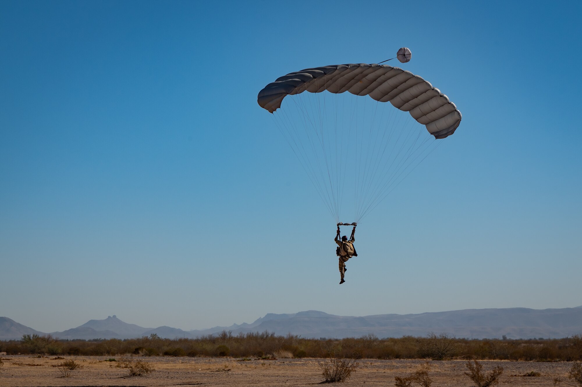 A U.S. Air Force Airman touches down at the landing zone during Exercise Desert Hammer 25-1 at Auxiliary Airfield 6 near Gila Bend, Ariz., Nov. 14, 2024. Exercise Desert Hammer 25-1 emphasizes the U.S. Air Force Reserve’s commitment to readiness by integrating Agile Combat Support and Large Force Exercise capabilities in a contested environment. (U.S. Air Force photo by Tech. Sgt. Tyler J. Bolken)