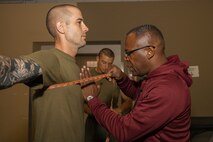 U.S. Marine Corps Recruit William Clifford with Lima Company, 3rd Recruit Training Battalion, is measured during his uniform fitting at Marine Corps Recruit Depot San Diego, California, Nov. 27, 2024. Recruits are fitted twice during training, on Training Day 27 in Phase 2 and the sixth day of Marine Week in Phase 4, to ensure their uniforms are ready to be worn properly as Marines. (U.S. Marine Corps photo by Lance Cpl. Janell B. Alvarez)