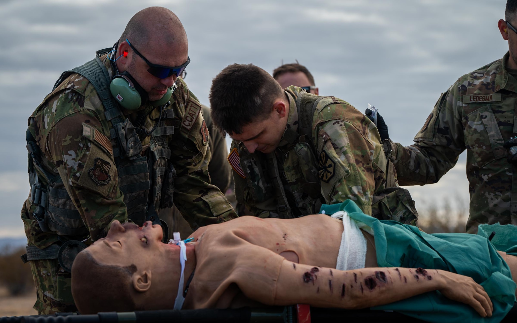 944th Fighter Wing U.S. Air Force Reserve Citizen Airmen and Arizona Army National Guard Soldiers lift a simulated casualty onto a stretcher during Exercise Desert Hammer 25-1 at Auxiliary Field 6 near Gila Bend, Ariz., Nov. 16, 2024. Through joint and multinational collaboration, Desert Hammer tests the ability of over 700 participants and 131 aircraft to operate, defend, and sustain airbases under austere conditions. (U.S. Air Force photo by Senior Airman Jacob Dastas)
