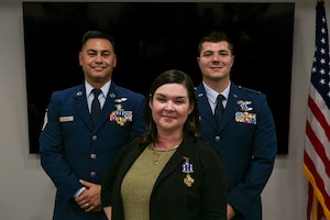 Pictured left to right:  U.S. Air Force Master Sgt. Jerry Thorn, Aeromedical Evacuation Technician, U.S. Air Force Capt. Megan Taggart, Flight Nurse, and U.S. Air Force Lt. Joseph Hansen, Flight Nurse, all from the 914th Aeromedical Evacuation Squadron, receive the Distinguished Flying Cross Award at the Niagara Falls Air Reserve Station, New York, Dec. 8, 2024.