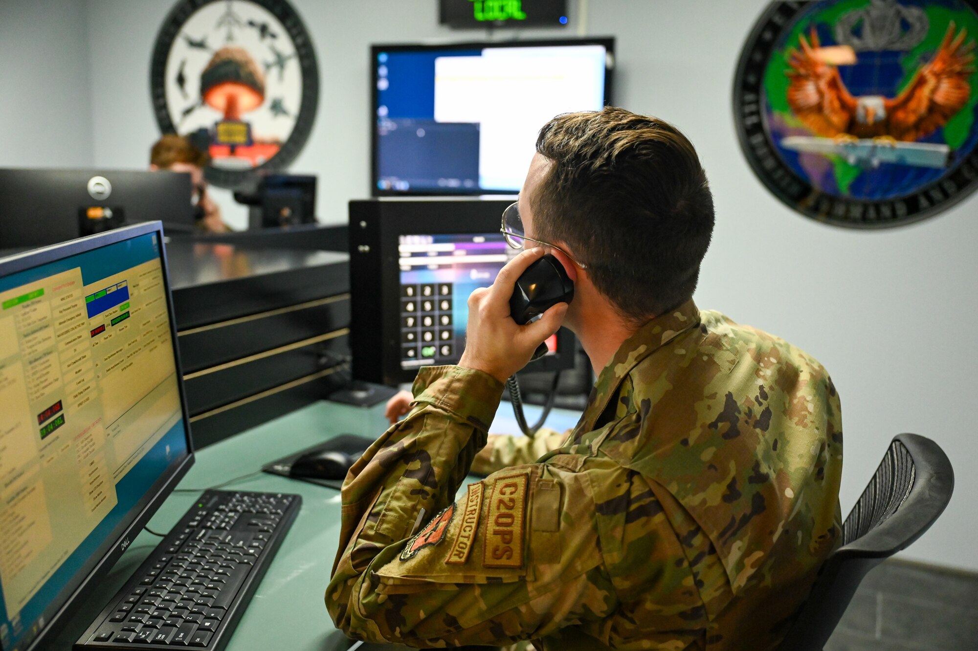U.S. Air Force Staff Sgt. Grant Welsh, 334th Training Squadron instructor, communicates a simulated emergency notification message to a student in the new command post study room on Keesler Air Force Base, Mississippi, Oct. 30, 2024.