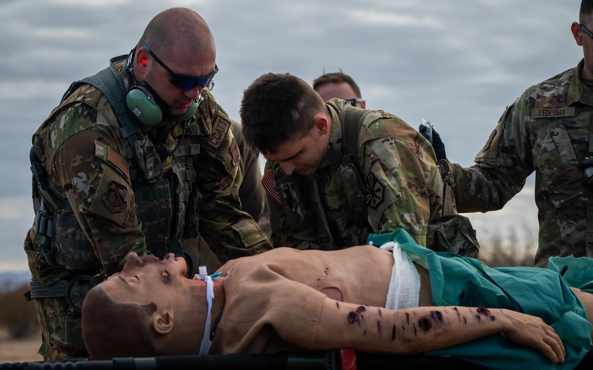 944th Fighter Wing U.S. Air Force Reserve Citizen Airmen and Arizona Army National Guard Soldiers lift a simulated casualty onto a stretcher during Exercise Desert Hammer 25-1 at Auxiliary Field 6 near Gila Bend, Ariz., Nov. 16, 2024. Through joint and multinational collaboration, Desert Hammer tests the ability of over 700 participants and 131 aircraft to operate, defend, and sustain airbases under austere conditions. (U.S. Air Force photo by Senior Airman Jacob Dastas)