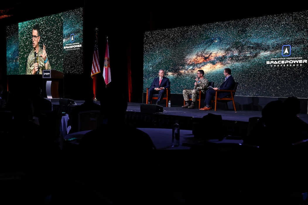 Air Marshal Paul Godfrey, assistant chief of space operations for future concepts and partnerships, speaks with Steven Ruehl, left, director of policy and programs for the deputy undersecretary of the Air Force for international affairs, and the panel moderator during the Space Force Association’s 2024 Spacepower Conference in Orlando, Fla., Dec. 10, 2024. 