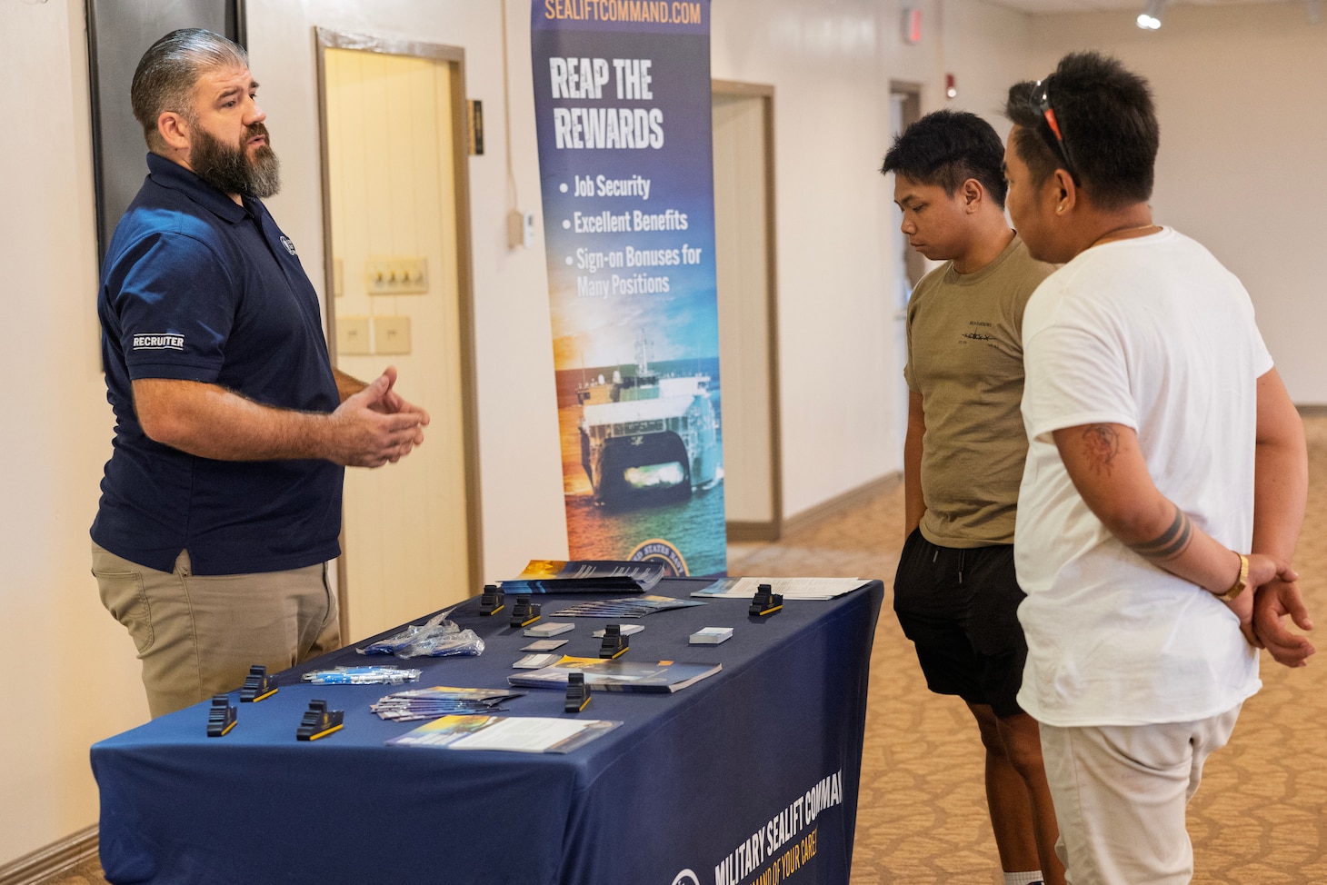 Michael Mack, field recruiter, Military Sealift Command, speaks to interested applicants at a job fair in the Top o’ the Mar reception center at the Nimitz Hill Annex, in Asan, Dec. 11.