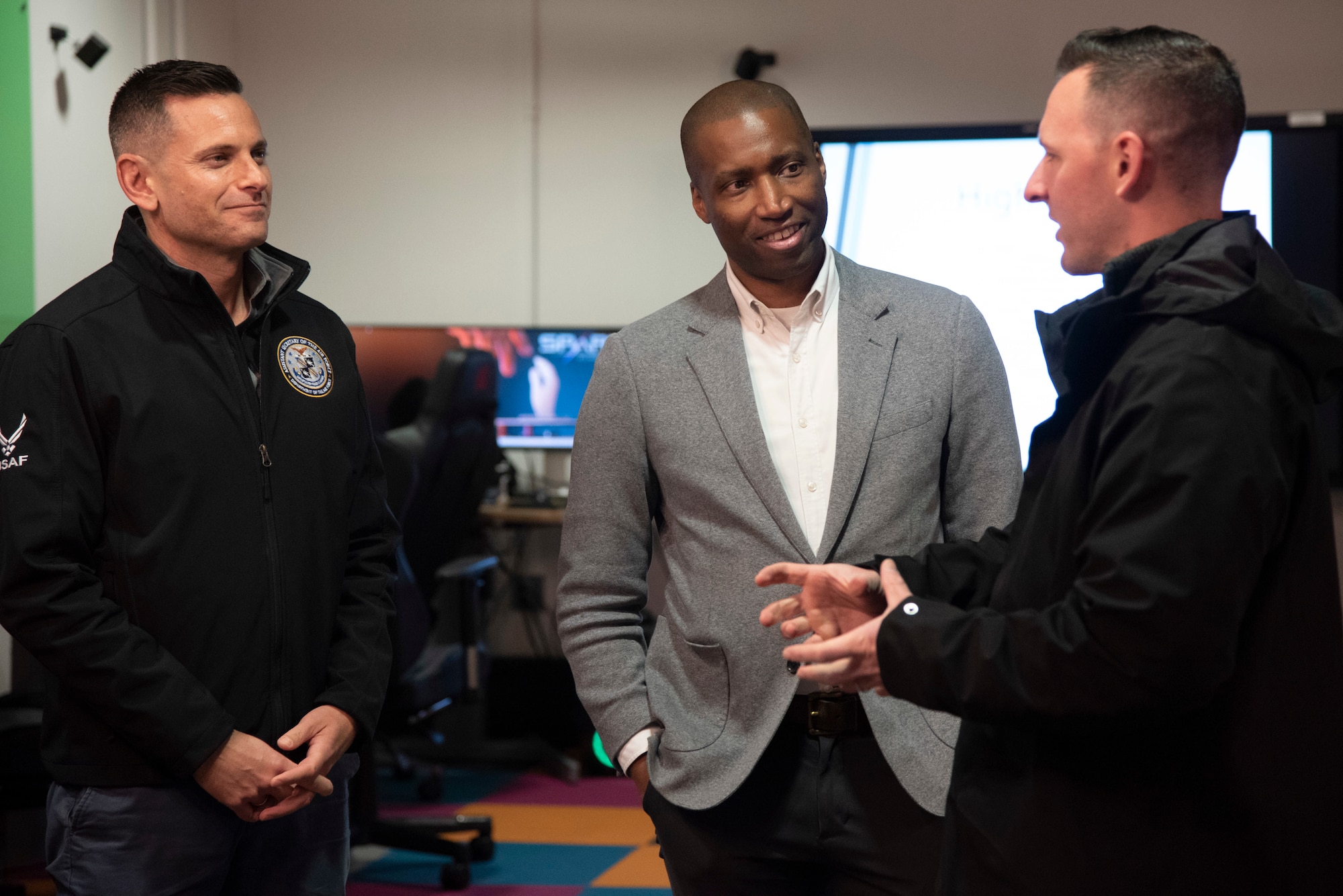 The Honorable Alex Wagner, assistant secretary of the Air Force for Manpower and Reserve Affairs, and Anthony Woods, secretary of the Maryland Department of Veterans and Military Families, speak with U.S. Air Force Tech. Sgt. Peter Archer, Spark X Innovation and Idea Center senior enlisted leader.