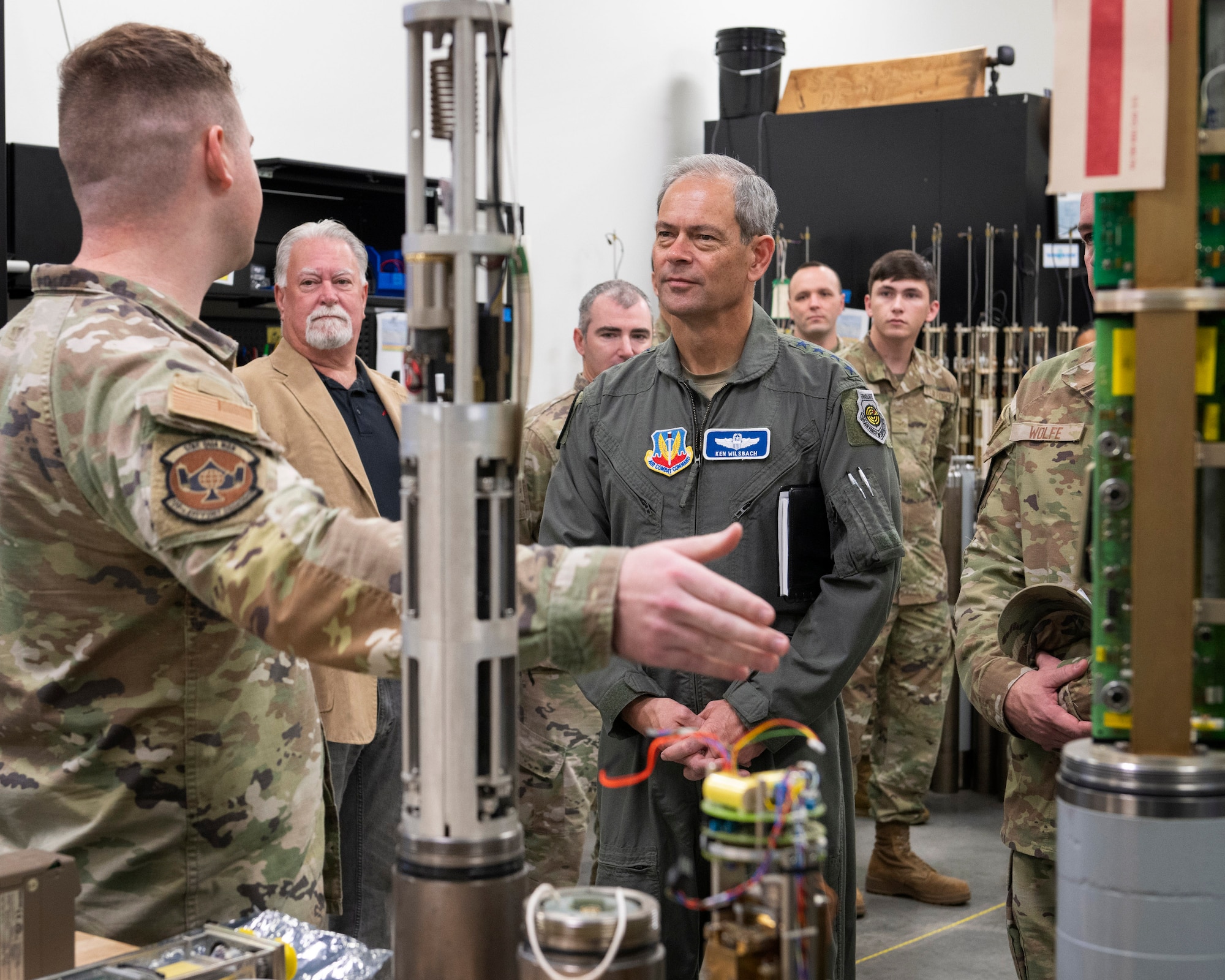 Senior Airman Ryland Smith, far left, a geophysical maintenance technician with the 709th Support Squadron, briefs Gen. Ken Wilsbach, commander of Air Combat Command, during his visit to the Air Force Technical Applications Center Dec. 5, 2024.  Smith described the function of precision seismic equipment and how it relates to AFTAC’s global seismic enterprise during the general’s visit to Patrick Space Force Base, Fla.  (U.S. Air Force photo by Matthew S. Jurgens)
