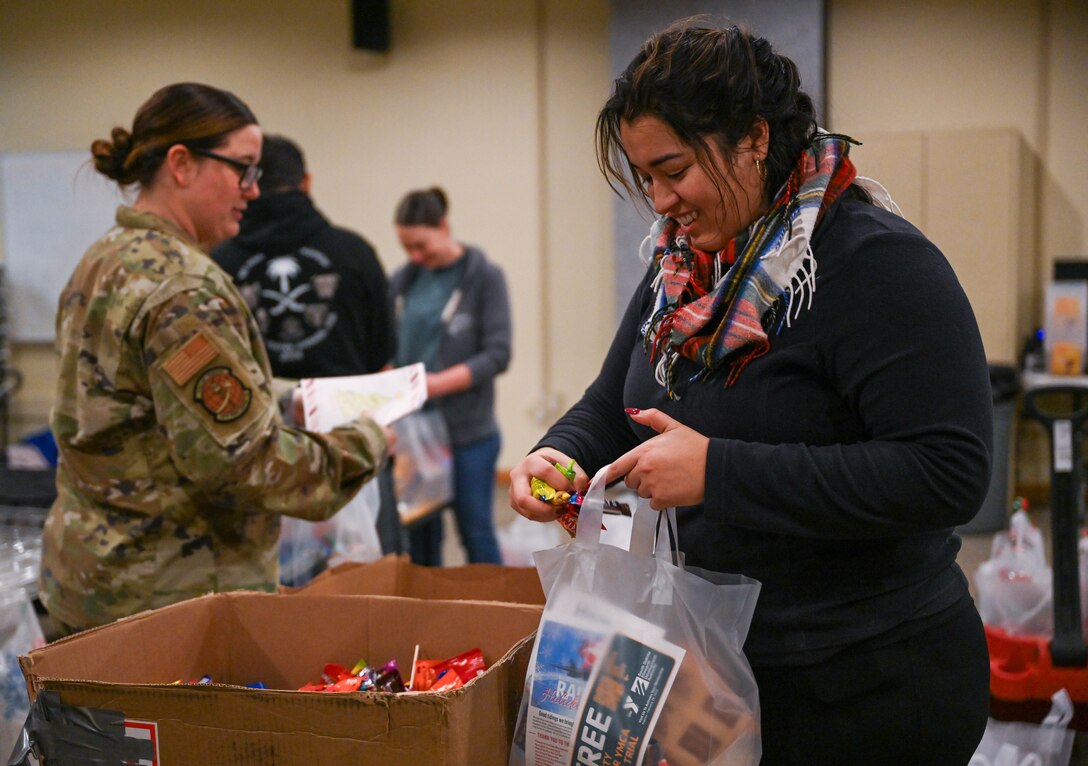 A volunteer assembles a gift bag for airmen living in the dorms