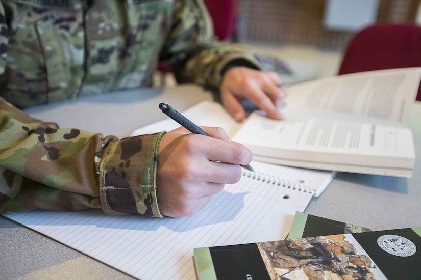 A soldier writes in a notebook.