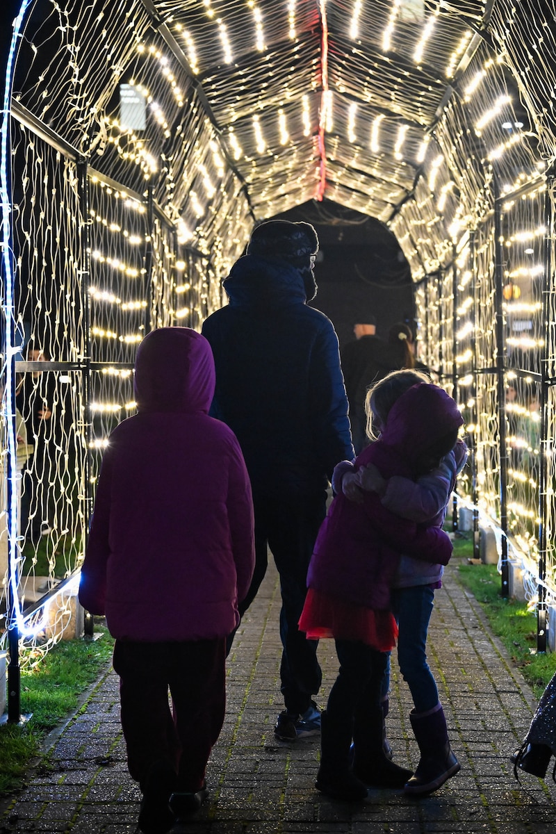 Children walk through a Christmas light arc at RAF Lakenheath.
