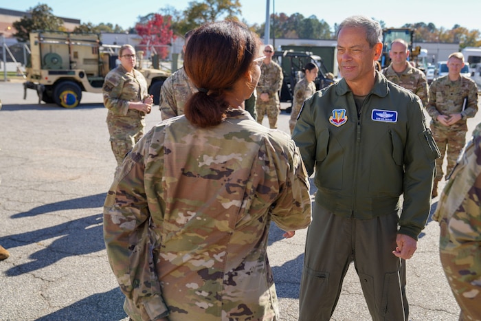 U.S. Air Force Gen. Ken Wilsbach, commander of Air Combat Command, presents his commander’s coin to U.S. Air Force Senior Airman Aniya Gaines,