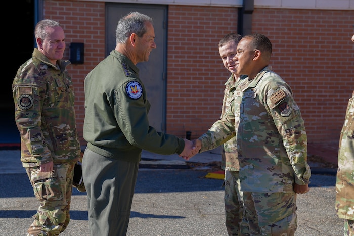 U.S. Air Force Gen. Ken Wilsbach, commander of Air Combat Command, presents his commander’s coin to U.S. Air Force Airman 1st Class Scootie Strong, 52nd Combat Communications Squadron network system operation technician.