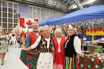Polish guests pose for a photo during CENTCOM's International Night, proudly wearing their traditional tri-national attire, celebrating cultural diversity and unity among partner nations. (U.S. Central Command Public Affairs photo by Maged Benjamin-Elias)