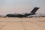 people walk up back of ramp of airplane