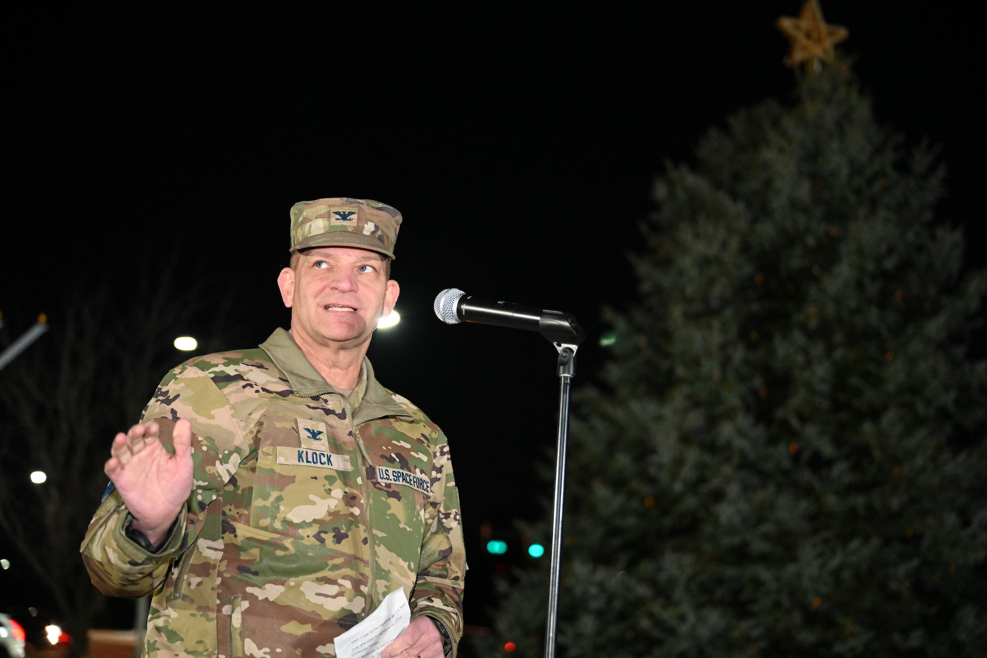 Col. Klock stands with the Christmas tree unlit in the background.