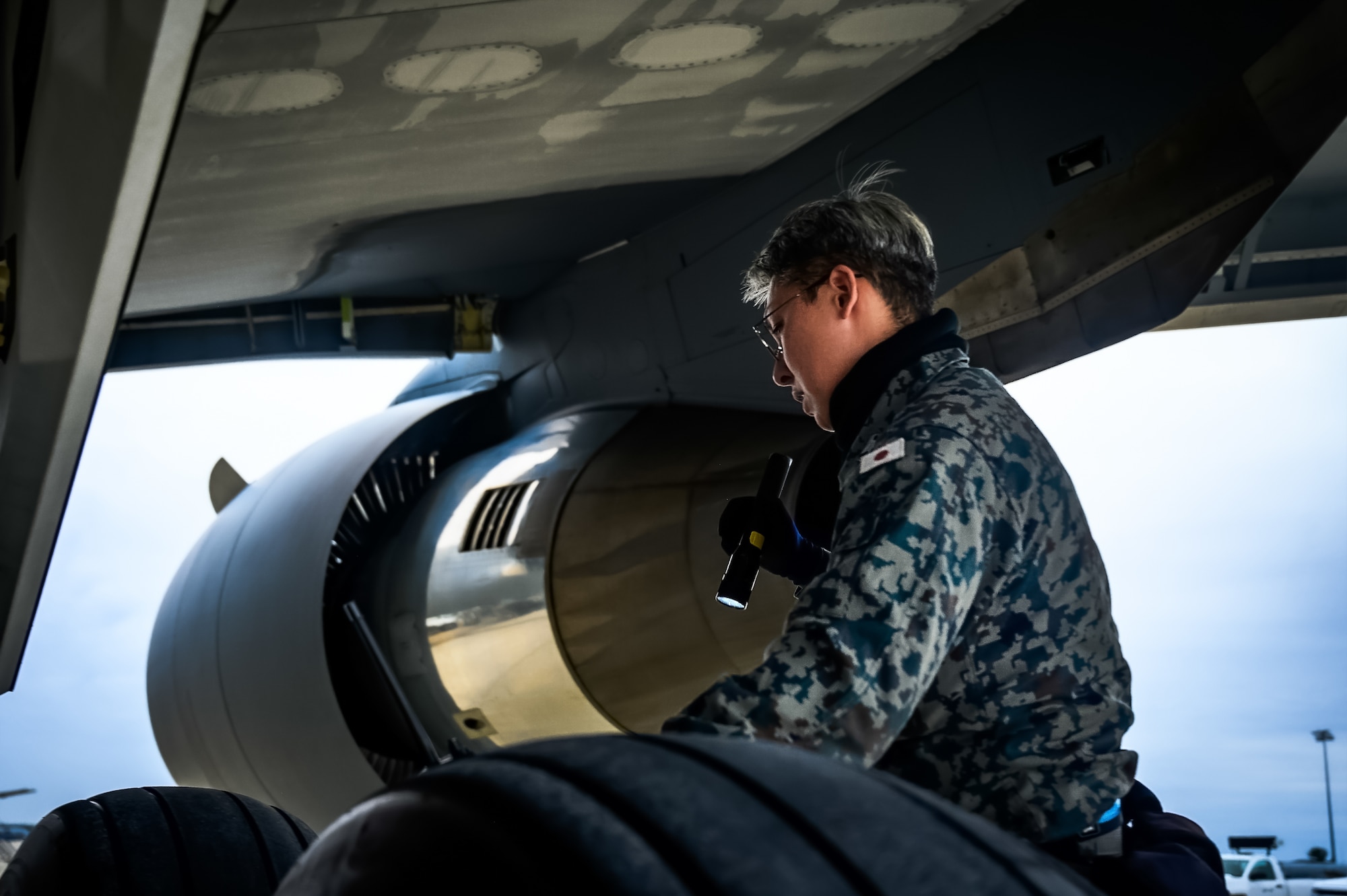 Japan Air Self-Defense Force Senior Airman Yuya Kaneda, 3rd Tactical Airlift Wing aircraft maintainer, performs a maintenance inspection on a KC-46A aircraft at Joint Base McGuire-Dix-Lakehurst, N.J., Dec. 9, 2024. The JASDF visit involved a subject matter expert exchange designed to enhance interoperability with U.S. Air Force KC-46A aircraft units. (U.S. Air Force photo by Senior Airman Matt Porter)