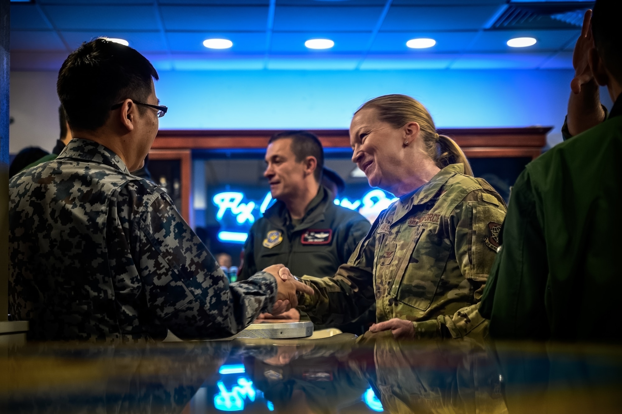 U.S. Air Force Col. Kathleen Hasson, 305th Air Mobility Wing commander, greets an Airman assigned to the Japan Air Self-Defense 3rd Tactical Airlift Wing at Joint Base McGuire-Dix-Lakehurst, N.J., Dec. 10, 2024. The JASDF visit involved a subject matter expert exchange designed to enhance interoperability with U.S. Air Force KC-46A aircraft units. (U.S. Air Force photo by Senior Airman Matt Porter)