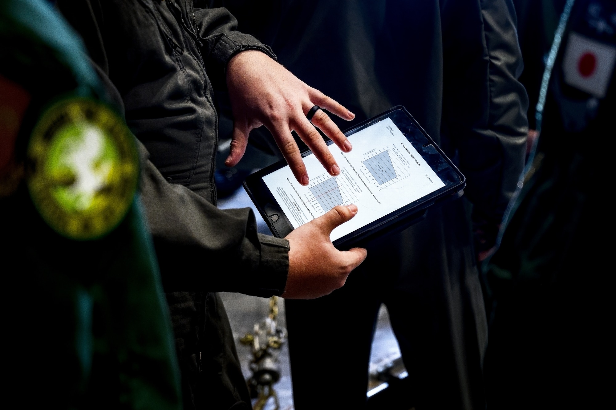 U.S. Air Force Senior Airman Brandon Rivas, 32nd Air Refueling Squadron boom operator, instructs Japan Air Self-Defense Force Airmen assigned to the 3rd Tactical Airlift Wing on a tablet computer unmanned data link at Joint Base McGuire-Dix-Lakehurst, N.J., Dec. 10, 2024. The JASDF visit involved a subject matter expert exchange designed to enhance interoperability with U.S. Air Force KC-46A aircraft units. (U.S. Air Force photo by Senior Airman Matt Porter)