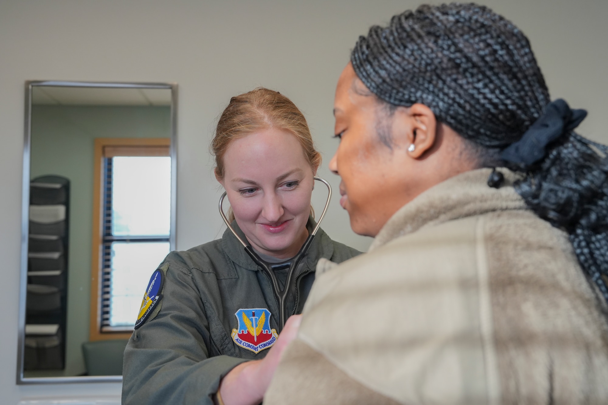 An airman examines a patient with a stethoscope.