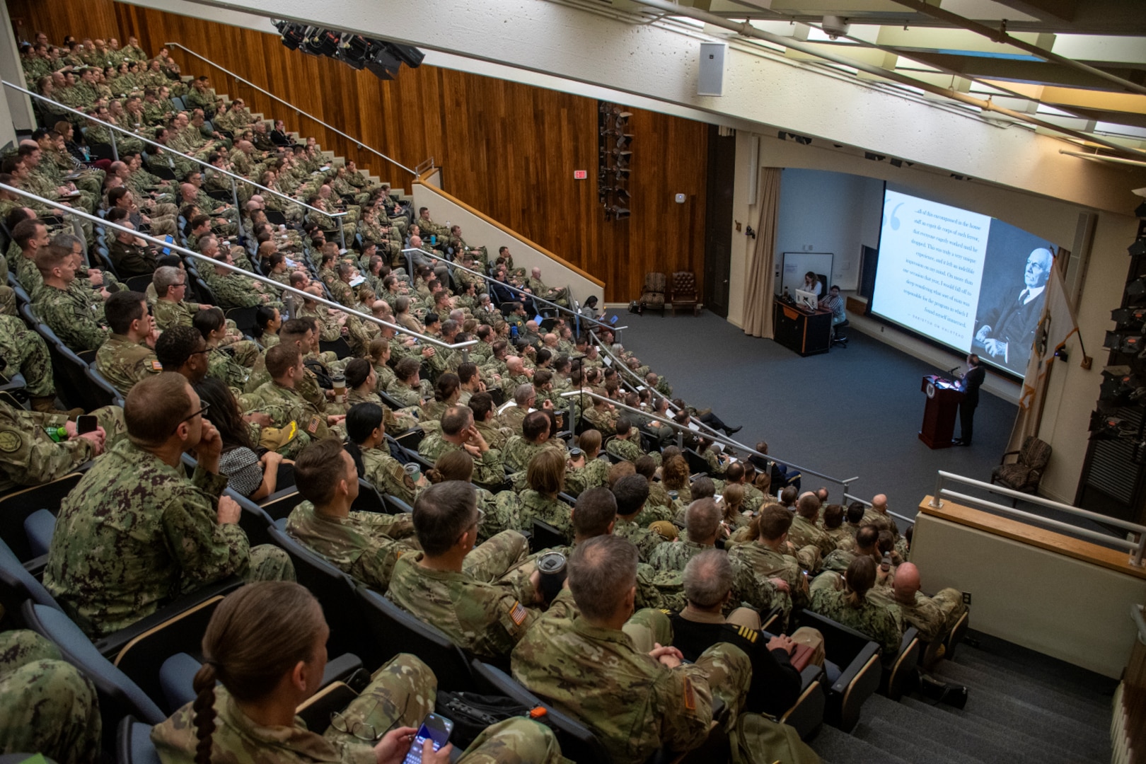 Auditorium full of uniformed service members.