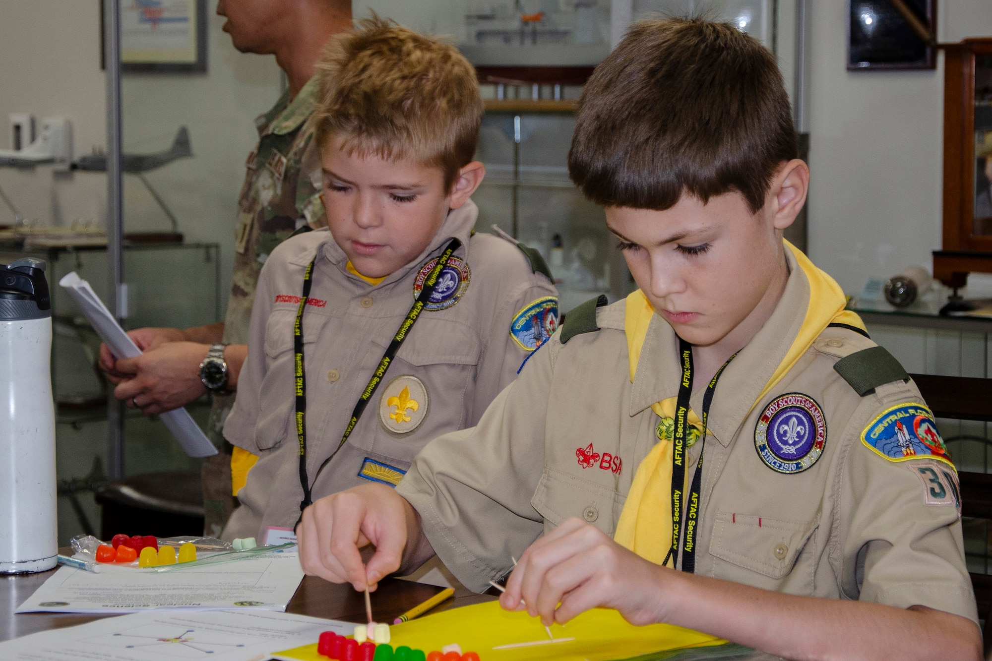 Two boy scouts from Central Florida work on creating a 3-D model of an element and its isotopes using colorful jellied candies and toothpicks.  The boys were two of 91 scouts and trailblazers who came to Patrick Space Force Base, Fla., to earn the coveted Nuclear Science Merit Badge with the assistance of volunteers from the Air Force Technical Applications Center, the Department of Defense’s sole nuclear treaty monitoring center.  (U.S. Air Force photo by Susan A. Romano)