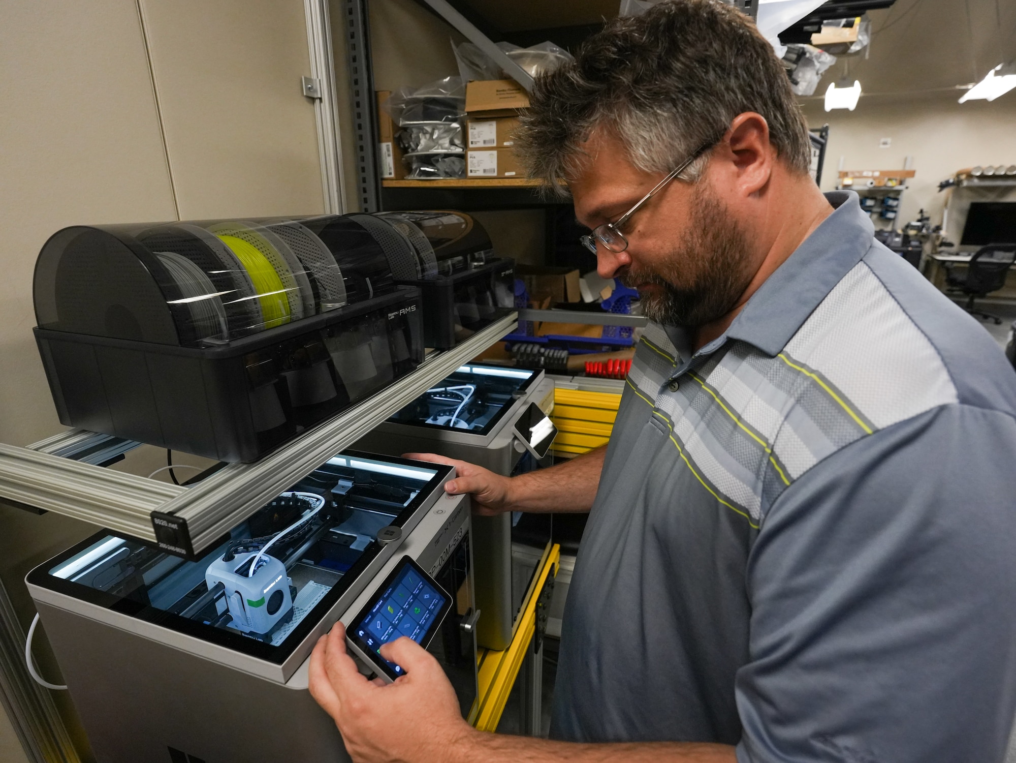 A person operates a 3D printer.
