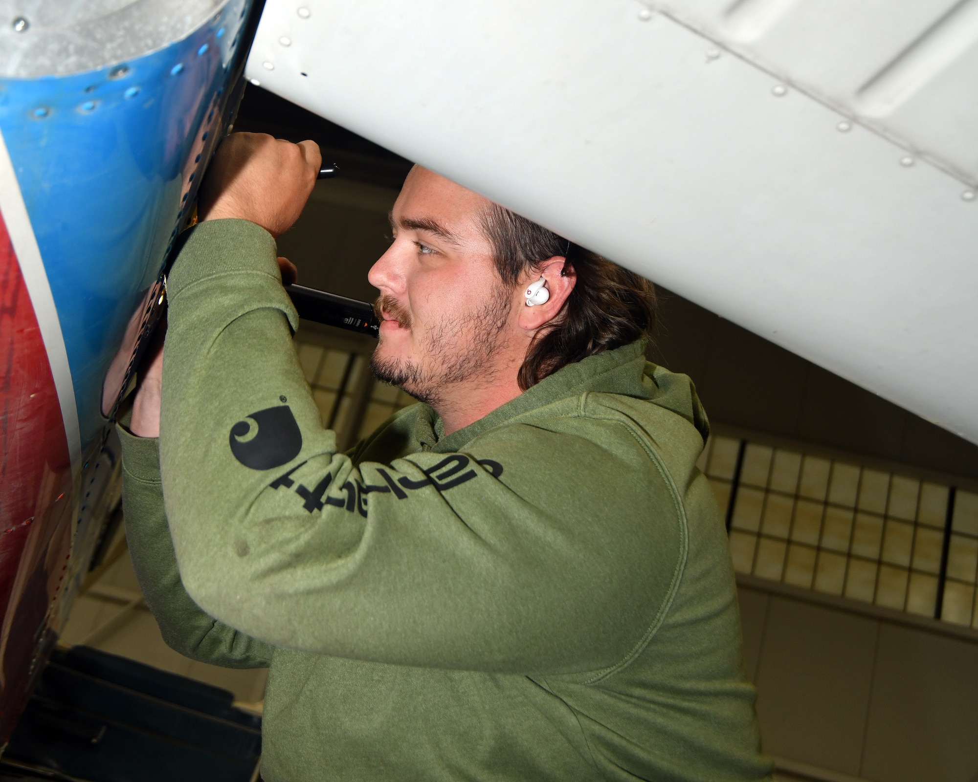 man working under airplane wing