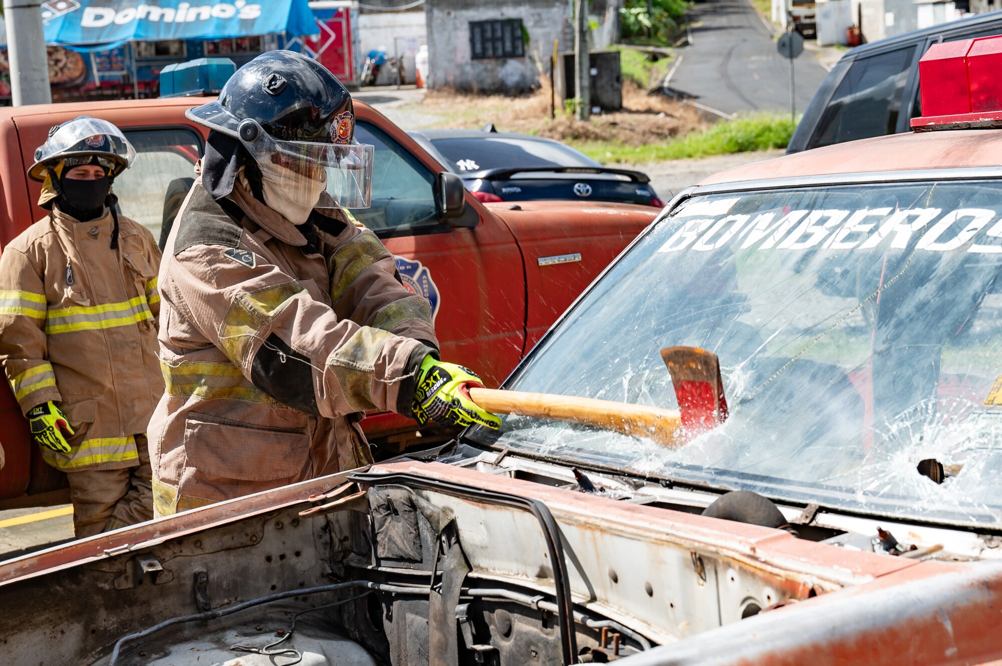 A Panama firefighter breaks a car windshield  during a training exercise in Chepo, Panama, Dec. 12, 2024.