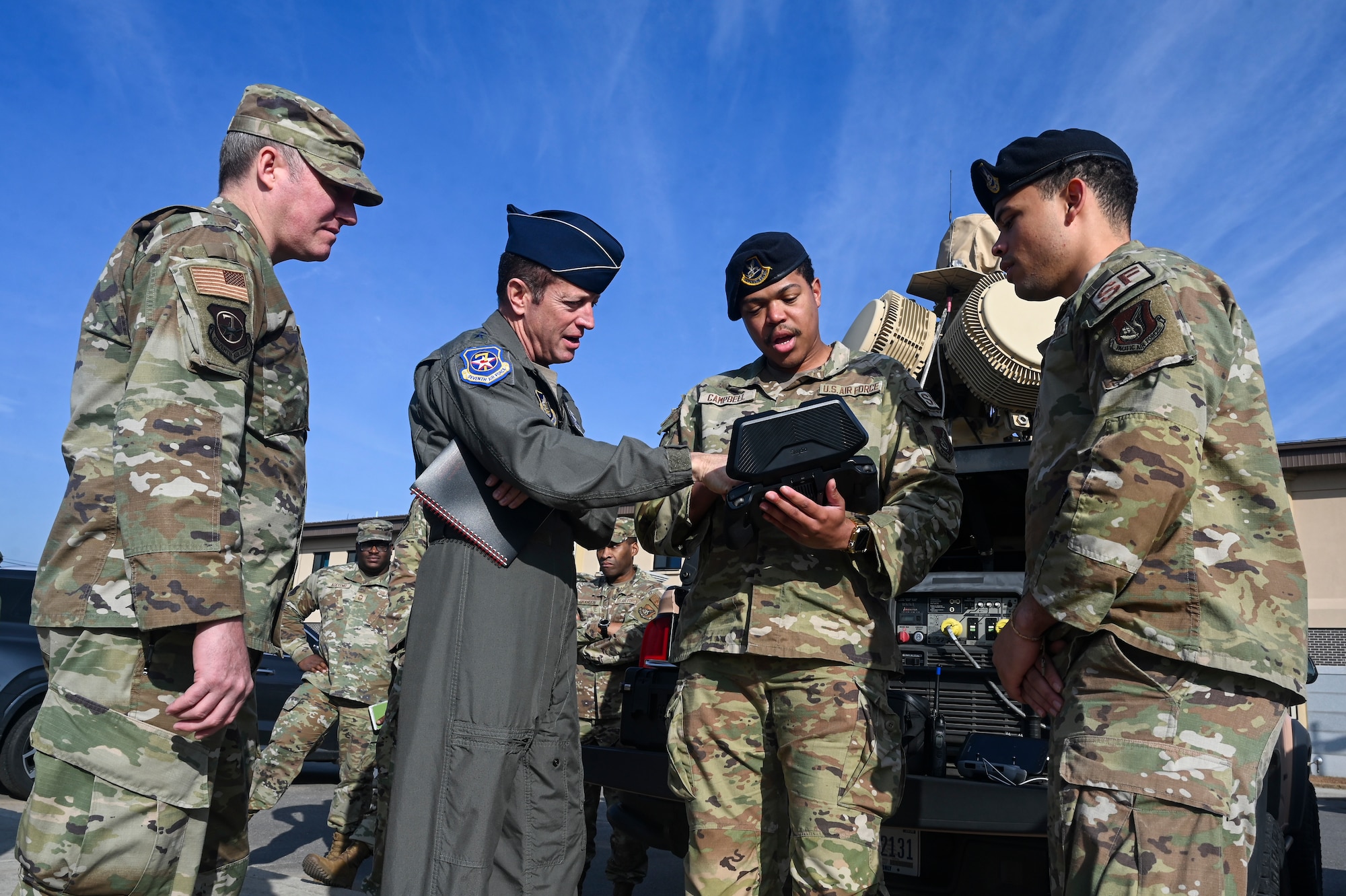 U.S. Air Force Lt. Gen. David R. Iverson, Seventh Air Force commander, and Chief Master Sgt. Jeremiah W. Ross, Seventh AF command chief, view a drone controller as they are briefed by Senior Airman Marcus Campbell, 8th Security Forces Squadron defender, during their visit at Kunsan Air Base, Republic of Korea.
