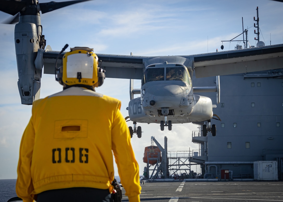 A U.S. Navy Sailor attached to the Expeditionary Sea Base (ESB) 6 USS John L. Canley watches a U.S. Marine Corps MV-22B Osprey prepare to land during a deck landing qualification training on the ship as part of exercise Warrior Voyage, off the coast of the island of O'ahu, Hawaii, Oct. 10, 2024. Exercise Warrior Voyage is a group-level training event that evaluates the ESB as an afloat platform for intermediate-level aviation logistics and hot refueling options in support of the Aviation Combat Element. (U.S. Marine Corps photo by Lance Cpl. Moses S. Lopez Franco)