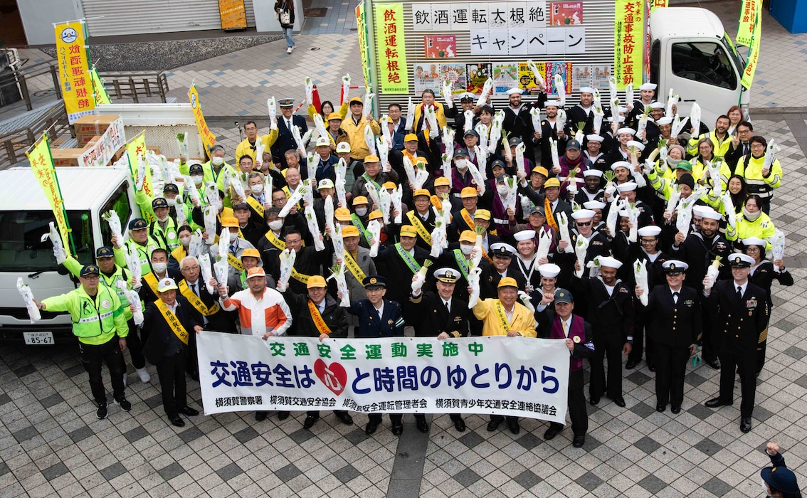 ailors stationed at Yokosuka Naval Base pose for a photo with Japanese participants of the year-end traffic safety campaign held at Keikyu Yokosuka Chuo Station. During the event, Sailors handed out Japanese daikon radishes to passers-by to raise awareness of the risk of drunken driving.