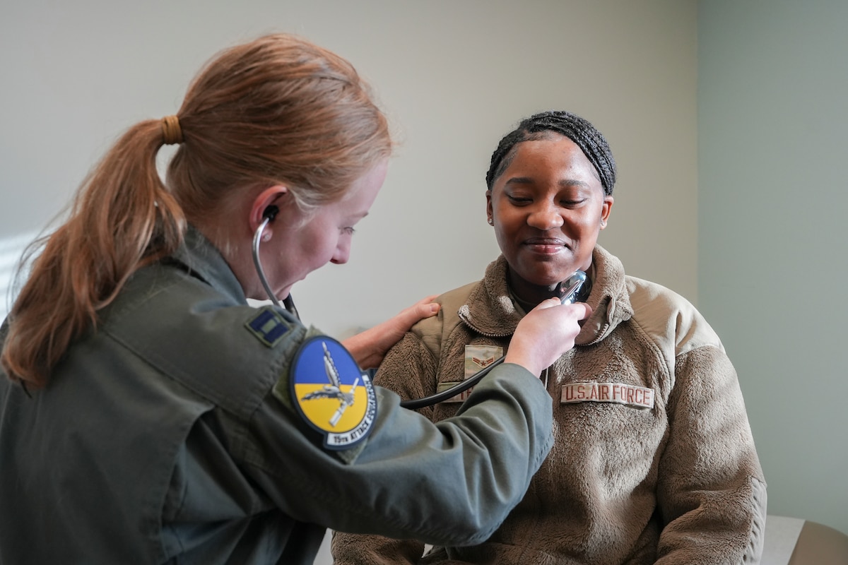 An airman examines a patient with a stethoscope.