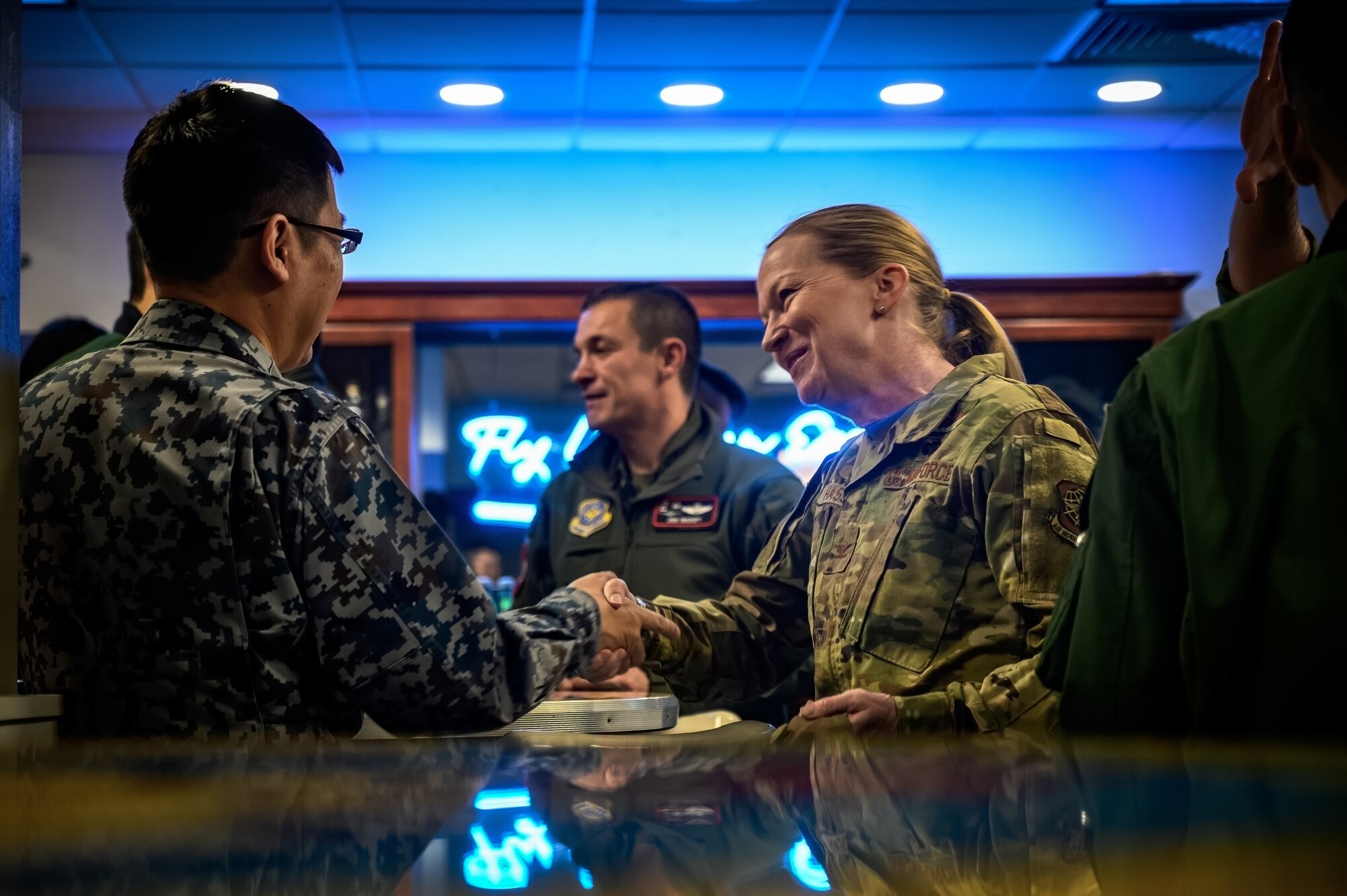 U.S. Air Force Col. Kathleen Hasson, 305th Air Mobility Wing commander, greets an Airman assigned to the Japan Air Self-Defense 3rd Tactical Airlift Wing at Joint Base McGuire-Dix-Lakehurst, N.J., Dec. 10, 2024. The JASDF visit involved a subject matter expert exchange designed to enhance interoperability with U.S. Air Force KC-46A aircraft units. (U.S. Air Force photo by Senior Airman Matt Porter)