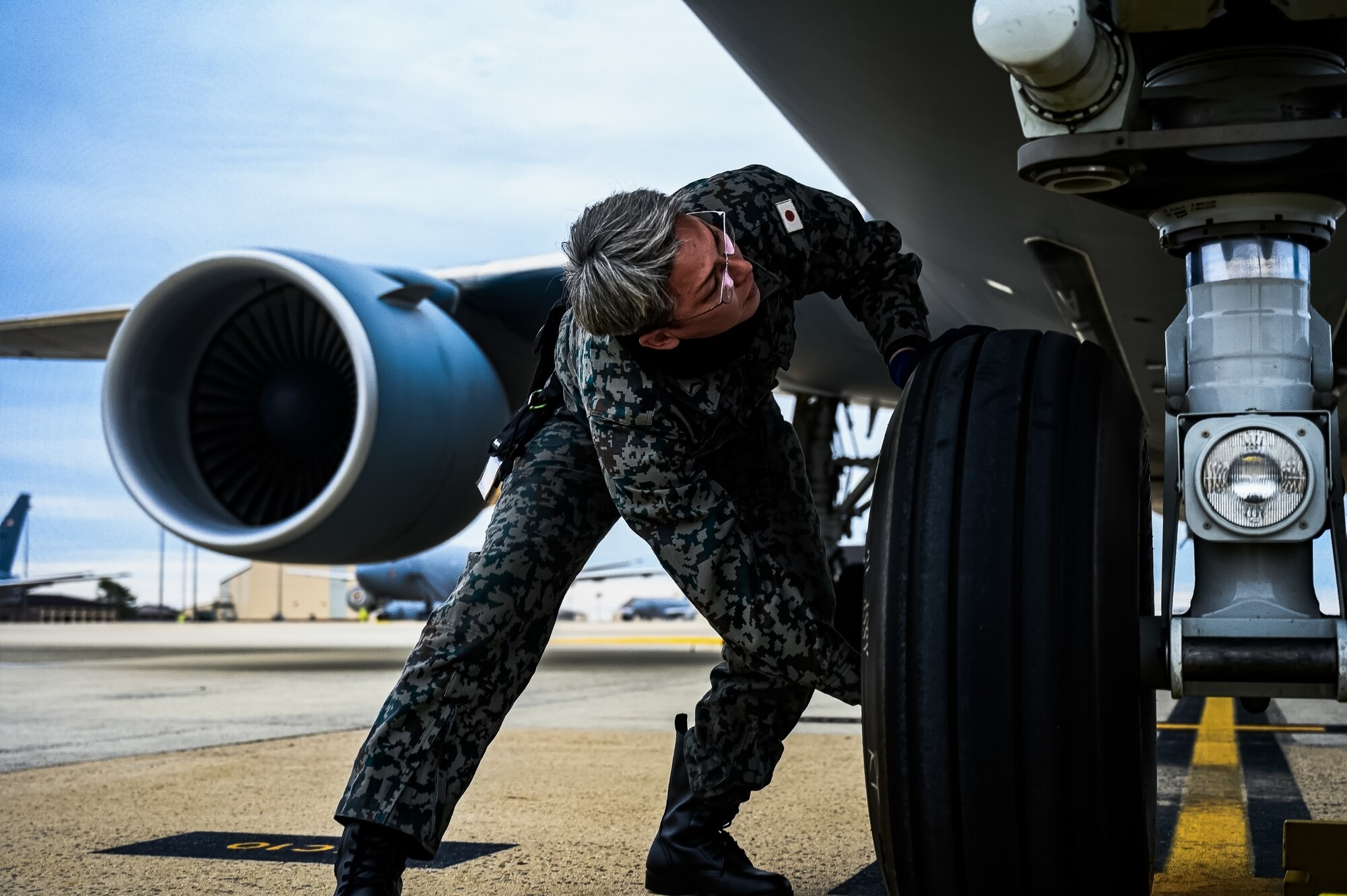 Japan Air Self-Defense Force Senior Airman Yuya Kaneda, 3rd Tactical Airlift Wing aircraft maintainer, performs a maintenance inspection on a KC-46A aircraft at Joint Base McGuire-Dix-Lakehurst, N.J., Dec. 9, 2024. The JASDF visit involved a subject matter expert exchange designed to enhance interoperability with U.S. Air Force KC-46A aircraft units. (U.S. Air Force photo by Senior Airman Matt Porter)