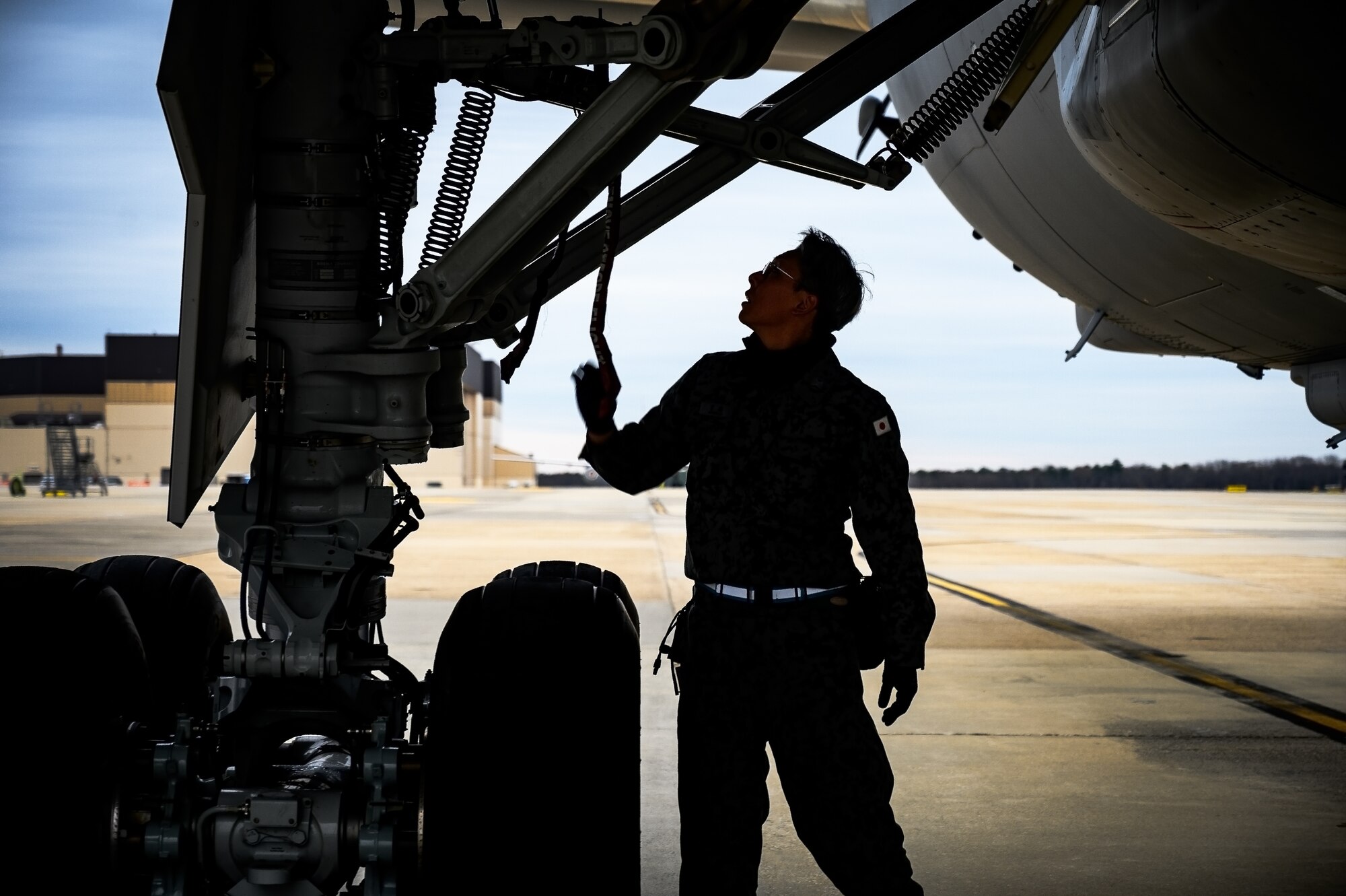 Japan Air Self-Defense Force Senior Airman Yuya Kaneda, 3rd Tactical Airlift Wing aircraft maintainer, performs a maintenance inspection on a KC-46A aircraft at Joint Base McGuire-Dix-Lakehurst, N.J., Dec. 9, 2024. The JASDF visit involved a subject matter expert exchange designed to enhance interoperability with U.S. Air Force KC-46A aircraft units. (U.S. Air Force photo by Senior Airman Matt Porter)