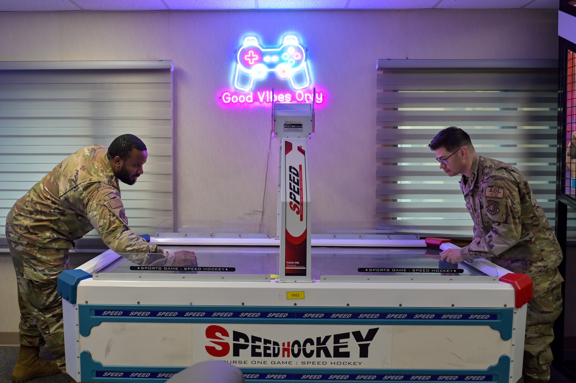 U.S. Air Force Staff Sgt. DeAndre Thomas, left, and Tech. Sgt. David Foglietti, right, 8th Civil Engineer Squadron Airman dorm leaders, play on the new speed hockey table in a dormitory dayroom after completed renovations at Kunsan Air Base, Republic of Korea.