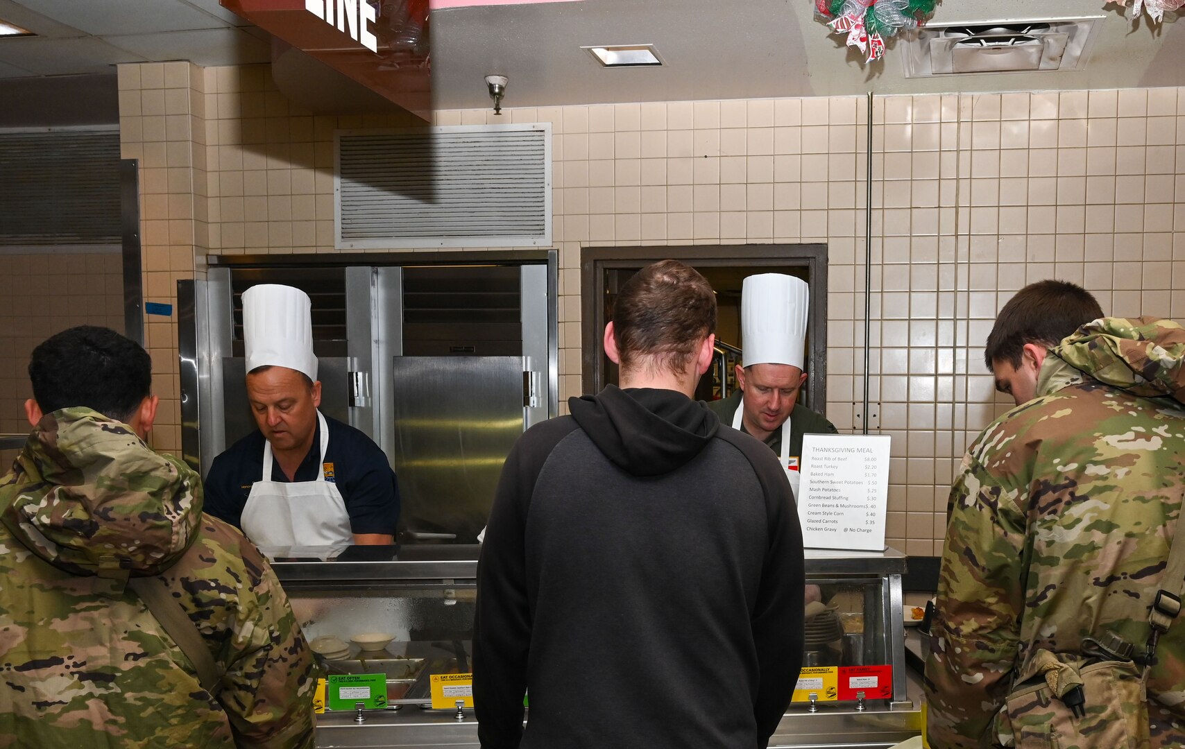 Honorary Commander Dave Bonney, First Command financial advisor, and Col. Douglas C. Jeffrey IV, 433rd Airlift Wing Commander, prepare plates of food for service members during the “Feed the Troops” event at the Live Oak Dining Facility on Joint Base San Antonio-Lackland, Texas, Dec. 7, 2024.