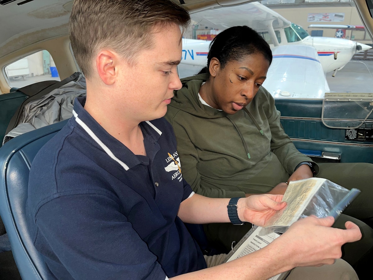 man and woman sitting in a plane and preparing for a flying lesson