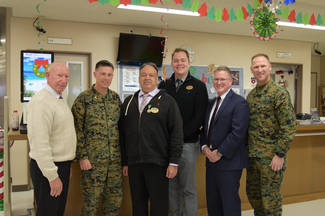 (Left to Right) Ed Hutsell, Col. Scott D. Welborn, Ceasar Hernandez, Matthew Schipper, Ed Cutshall, and Sgt. Maj. Christopher Gasser, pose for a group photo after Hernandez, Combined Arms Training Center, Camp Fuji Marine Corps Community Services, Marine and Family Program specialist was awarded a Civilian Service Commendation  medal, December 11, 2024.  Hernandez helped CATC Camp Fuji service members obtain more than $250,000 in tuition assistance since 2020.