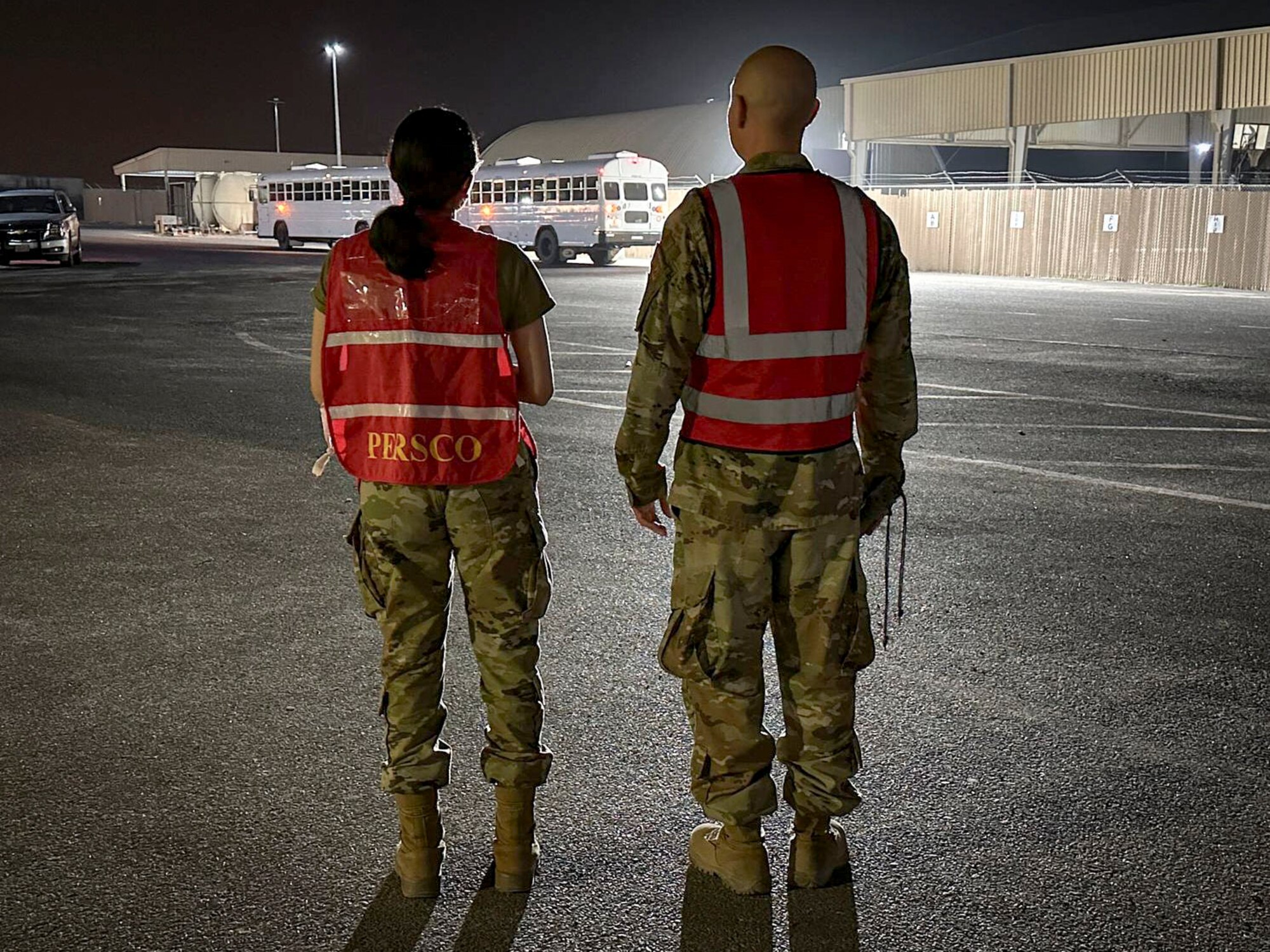 Two military members wearing red vests