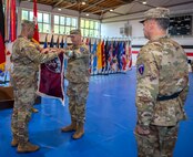 U.S. Army Col. Tracy Michael, commander (left) and Command Sgt. Maj. Kyle S. Brunell, senior enlisted advisor (right), both with the 68th Theater Medical Command, uncasing the unit flag for the first time during the activation ceremony, Sep. 20, 2024 at Sembach, Germany. The role of the 68th Theater Medical Command is to coordinate, integrate, and synchronize medical support across the Europe and Africa theaters. (U.S. Army Photo by Elisabeth Paqué)