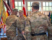 U.S. Army Col. Tracy Michael, commander (left) passes the unit colors to Command Sgt. Maj. Kyle S. Brunell, senior enlisted advisor (right), both with the 68th Theater Medical Command, during the activation ceremony, Sep. 20, 2024 at Sembach, Germany. The role of the 68th Theater Medical Command is to coordinate, integrate, and synchronize medical support across the Europe and Africa theaters. (U.S. Army Photo by Elisabeth Paqué)