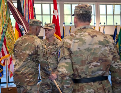 U.S. Army Col. Tracy Michael, commander (left) passes the unit colors to Command Sgt. Maj. Kyle S. Brunell, senior enlisted advisor (right), both with the 68th Theater Medical Command, during the activation ceremony, Sep. 20, 2024 at Sembach, Germany. The role of the 68th Theater Medical Command is to coordinate, integrate, and synchronize medical support across the Europe and Africa theaters. (U.S. Army Photo by Elisabeth Paqué)