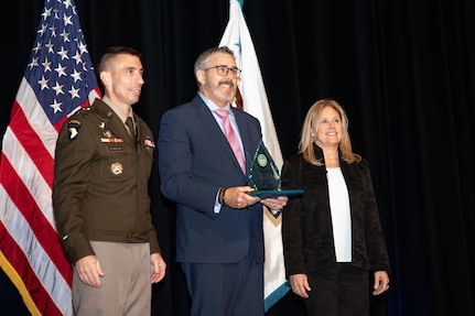 Shawn Achziger, center, an information technology specialist with the National Guard Bureau, with U.S. Army Lt. Gen. Paul Stanton, left, the director of the Defense Information Systems Agency, and Leslie Beavers, the acting chief information officer with the Department of Defense, after receiving a 2024 Department of Defense Chief Information Officer Award during a ceremony at the Pentagon Dec. 3, 2024. Achzinger was recognized for migrating the National Guard from the obsolete Joint Information Exchange Environment system to the updated Common Operating Picture system, used primarily during emergency response operations.