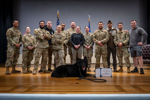 The 87th Security Forces K-9 unit poses with A312 Zak, 87th Security Forces Squadron military working dog, during his retirement ceremony Joint Base McGuire-Dix-Lakehurst, N.J., Nov. 26, 2024. Zak is retiring from the U.S. Air Force after six years of service. (U.S. Air Force photo by Jewaun McElroy)