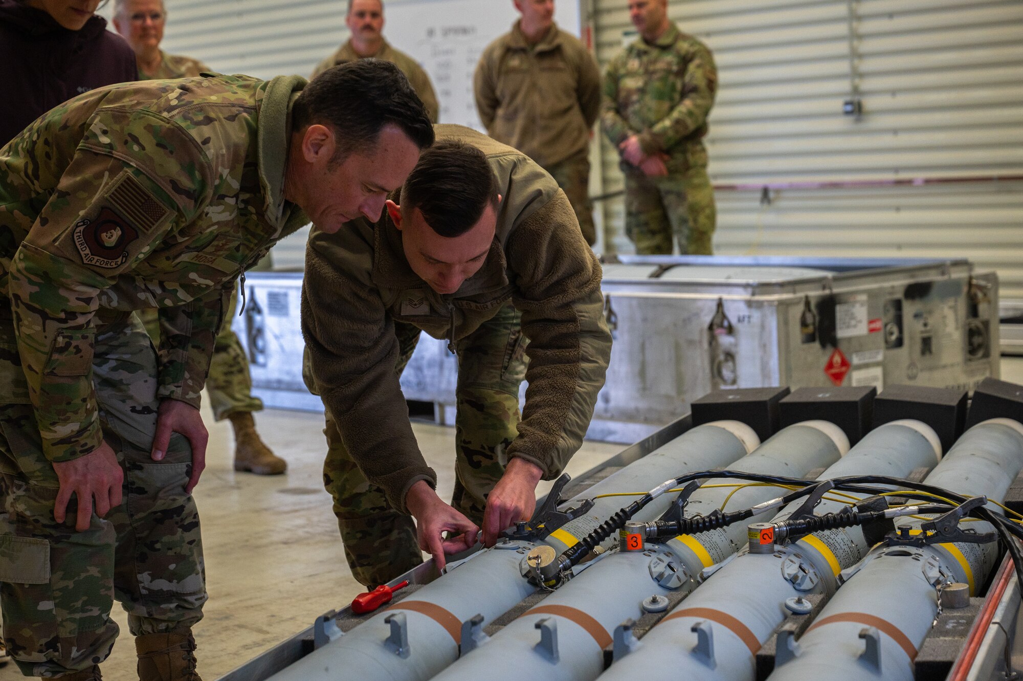 A man shows a munition to another man