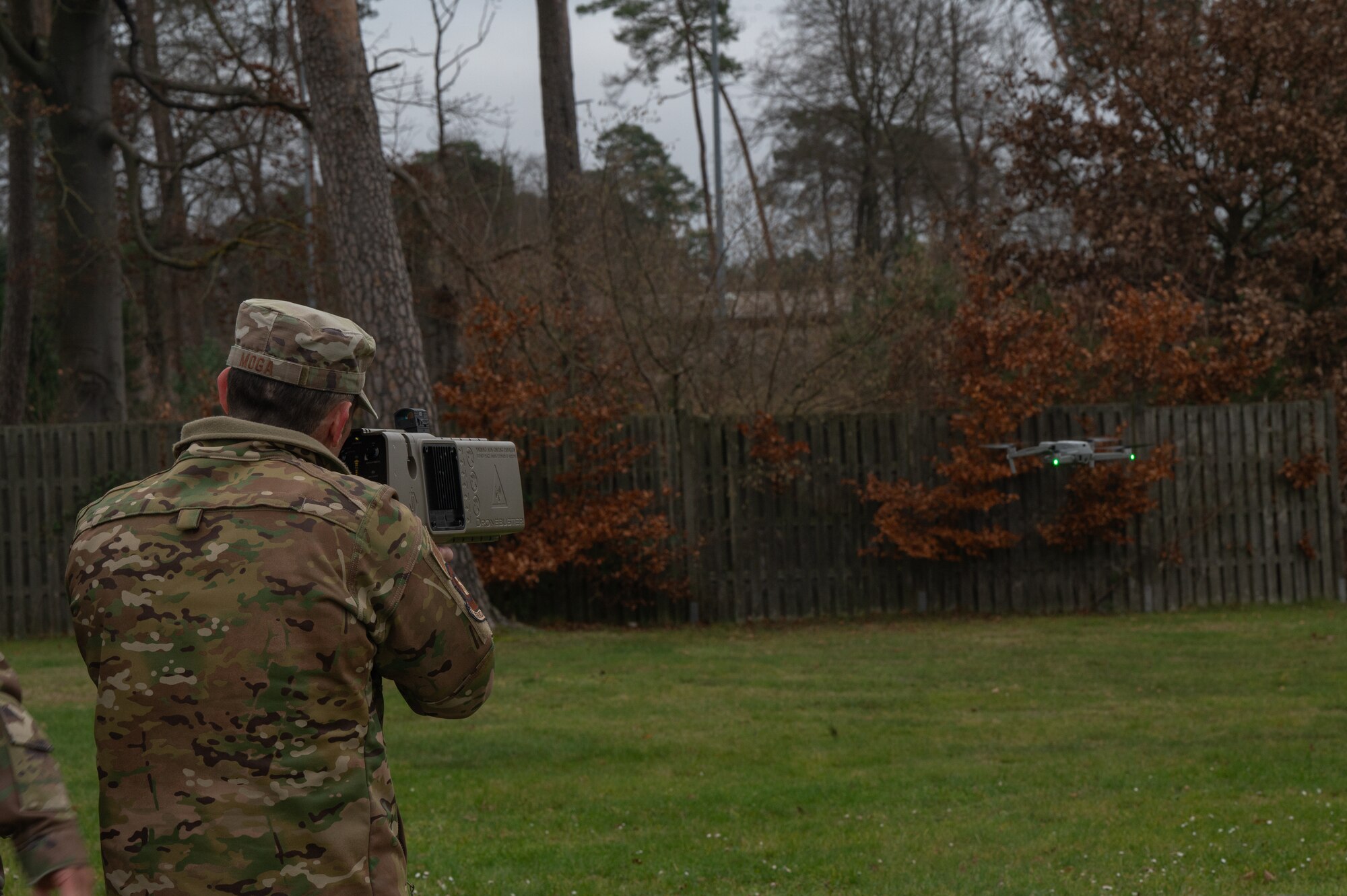 A man uses a drone buster to bring down a drone