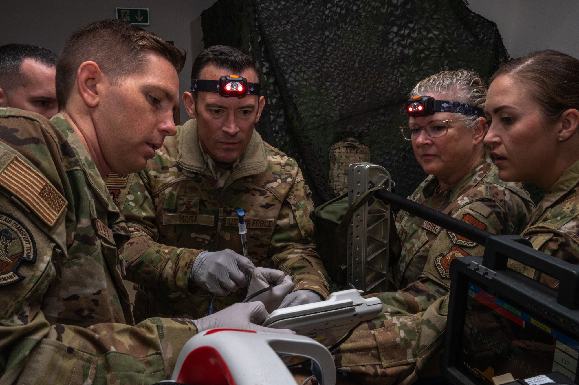 People work on a medical dummy during an exercise