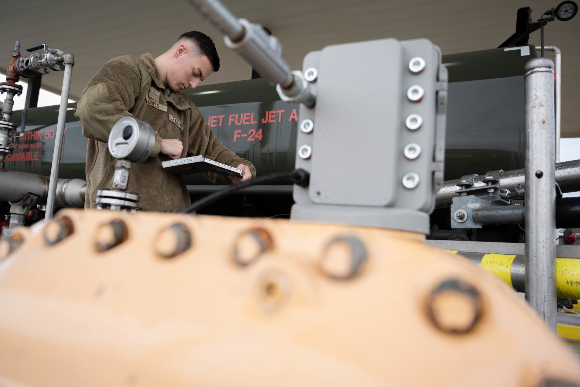 An Airmen checks logs for fuel truck.